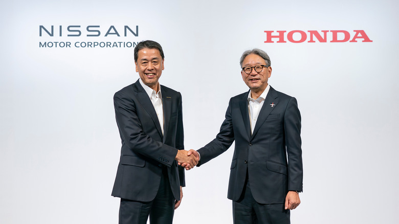 Executives from Nissan (left) and Honda shaking hands.