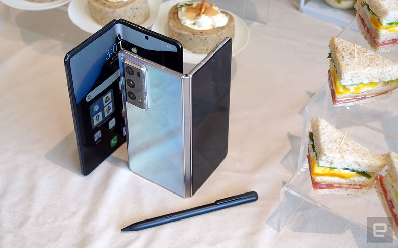 Two partially-opened Honor Magic V2 units stood vertically next to a stylus.