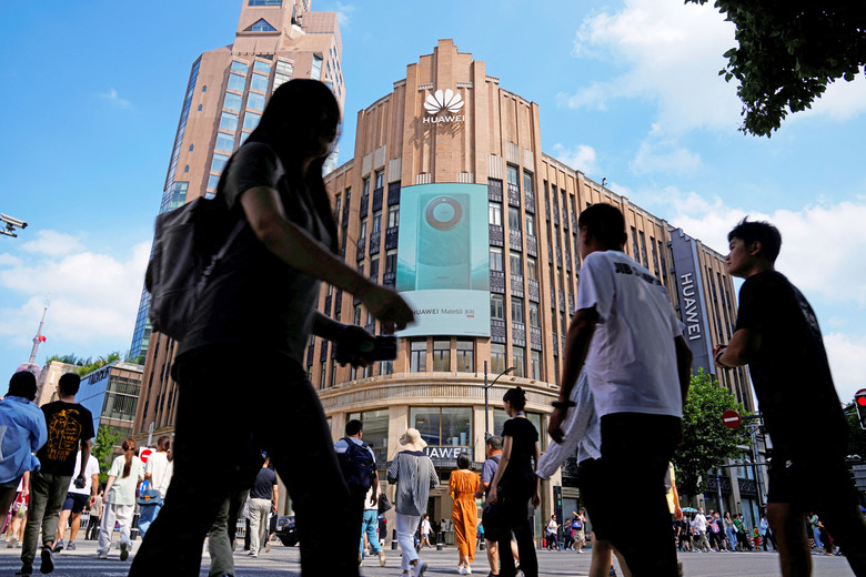 Pedestrians walk past an advertisement for Huawei's Mate 60 series smartphones outside a Huawei store in Shanghai, China September 8, 2023. 