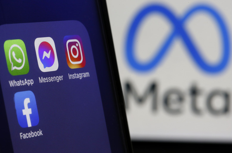 PARIS, FRANCE - FEBRUARY 03: In this photo illustration, The logos of applications, WhatsApp, Messenger, Instagram and facebook belonging to the company Meta are displayed on the screen of an iPhone in front of a Meta logo on February 03, 2022 in Paris, France. Share prices for Facebook's parent company, Meta, slumped in after-hours trading after the company reported that social network's daily active users declined to 1.929 billion in Q4 of 2021 from 1.930 billion in the previous quarter. Facebook is losing users for the first time in its history, Mark Zuckerberg's company has seen its profits decline, and the transition to the metaverse promises to be chaotic. (Photo illustration by Chesnot/Getty Images)