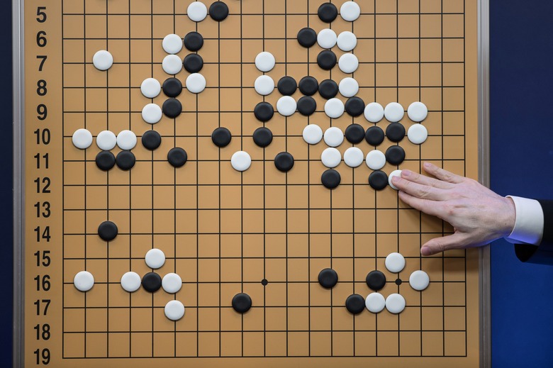 A commentator in a media room positions pieces forming a replica of a game between 'Go' player Lee Se-Dol and a Google-developed super-computer, in Seoul on March 13, 2016. A South Korean Go grandmaster scored his first win over a Google-developed supercomputer, in a surprise victory after three humiliating defeats in a high-profile showdown between man and machine. Lee Se-Dol thrashed AlphaGo after a nail-biting match that lasted for nearly five hours -- the fourth of the best-of-five series in which the computer clinched a 3-0 victory on March 12.   / AFP PHOTO / Ed Jones        (Photo credit should read ED JONES/AFP via Getty Images)