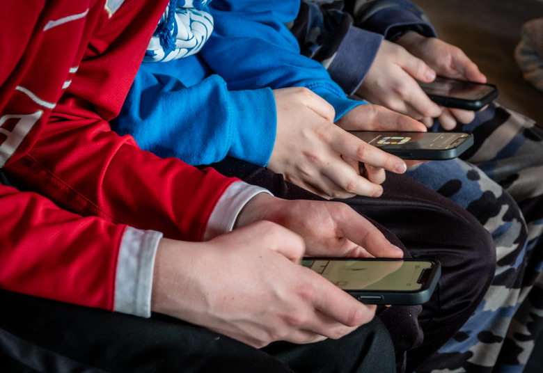 MORZINE, FRANCE - APRIL 08: Three teenage boys looks at their smartphone screens in village of St Jean d'Aulps on April 8, 2024 near Morzine, France. Following the lead of the EU Commission and several US administrations, TikTok is set to be banned from UK government phones amid security concerns around the Chinese-owned video app. Recently TikTok announced that every account belonging to a user below age 18 have a 60-minute daily screen time limit automatically set. (Photo by Matt Cardy/Getty Images)
