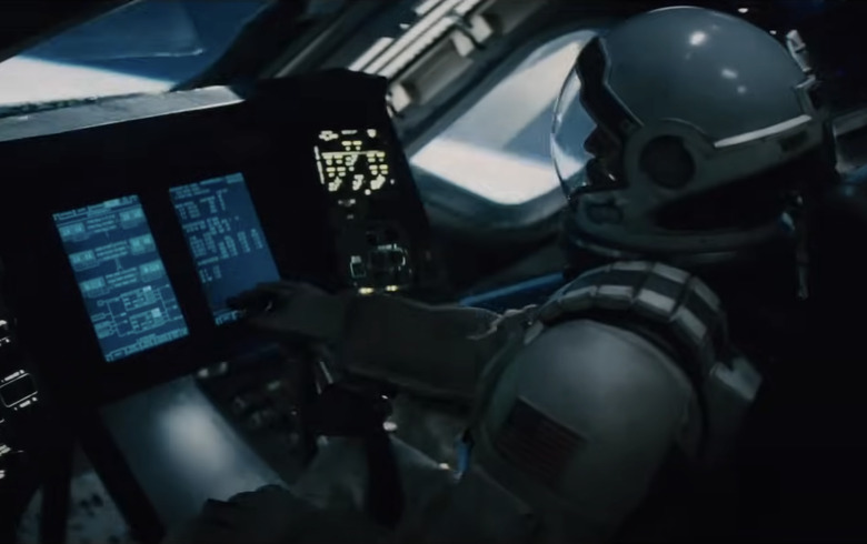 A still from the trailer for the movie Interstellar showing an astronaut sitting at a control panel in a space ship