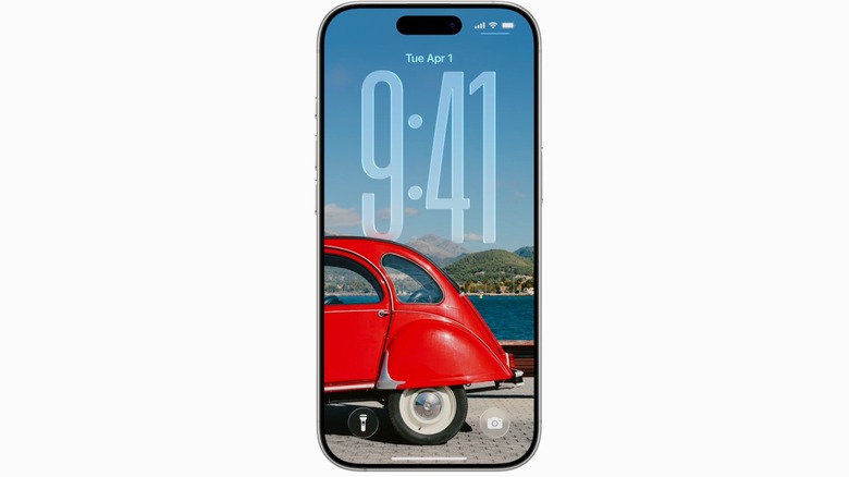 An iPhone's Lock Screen displaying a photo of the back half of a red, retro buggy-style car, and the time of 9:41, which is translucent against the background of a blue sky