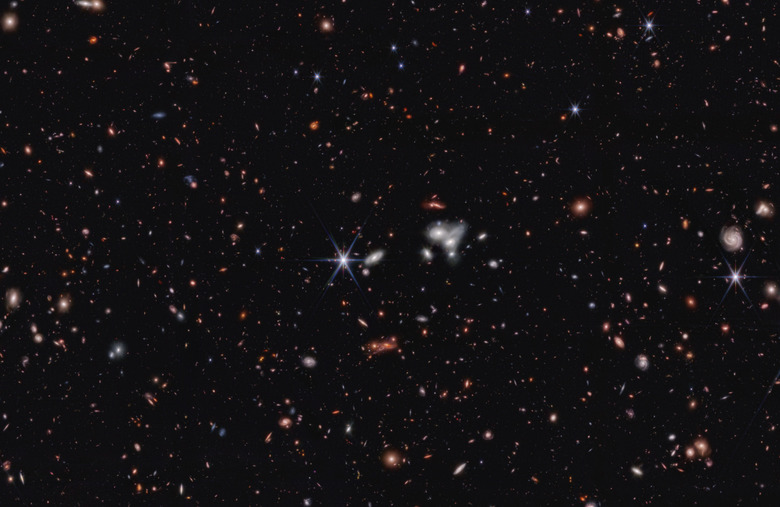 A photo of space with distant galaxies against a black background. 