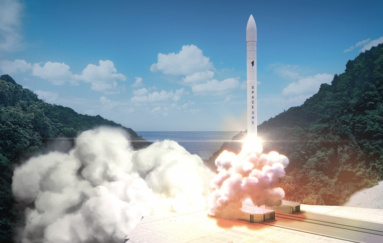 A computer graphics image of a white rocket blasting off against a background of blue skies and verdant hills.