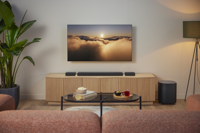 The JBL Bar 1000 MK2 with its detachable satellite speakers resting on a TV stand.