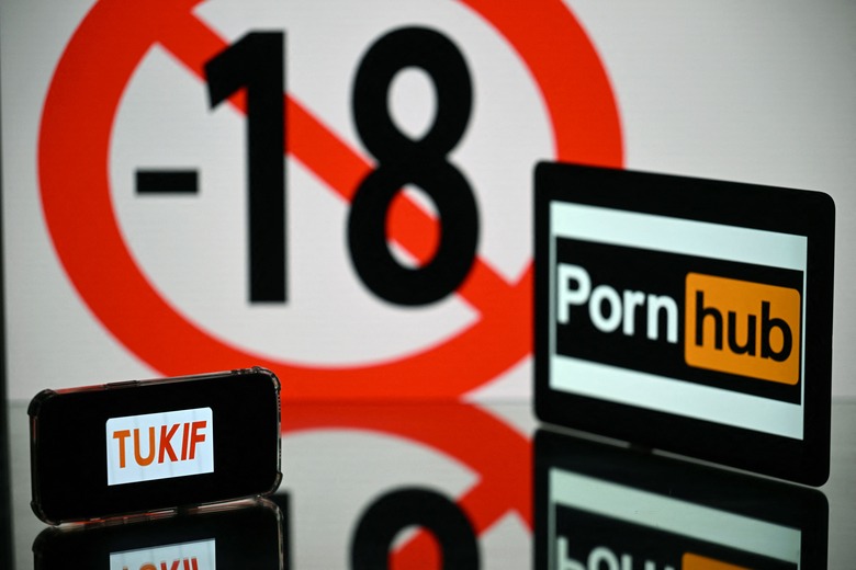 This photograph taken in Toulouse, southern France, shows screens displaying an age restriction warning sign and the logos of the pornographic sites Pornhub (R) and Tukif (L), on May 24, 2022. - The judicial examination of Arcom request against porn sites has been postponed to one month, on May 24, 2022. Arcom media regulator requests five pornographic sites to be blocked as they are not preventing the exposure of minors to their content, and French telecom operators to block access to the pornographic sites. (Photo by Lionel BONAVENTURE / AFP) (Photo by LIONEL BONAVENTURE/AFP via Getty Images)