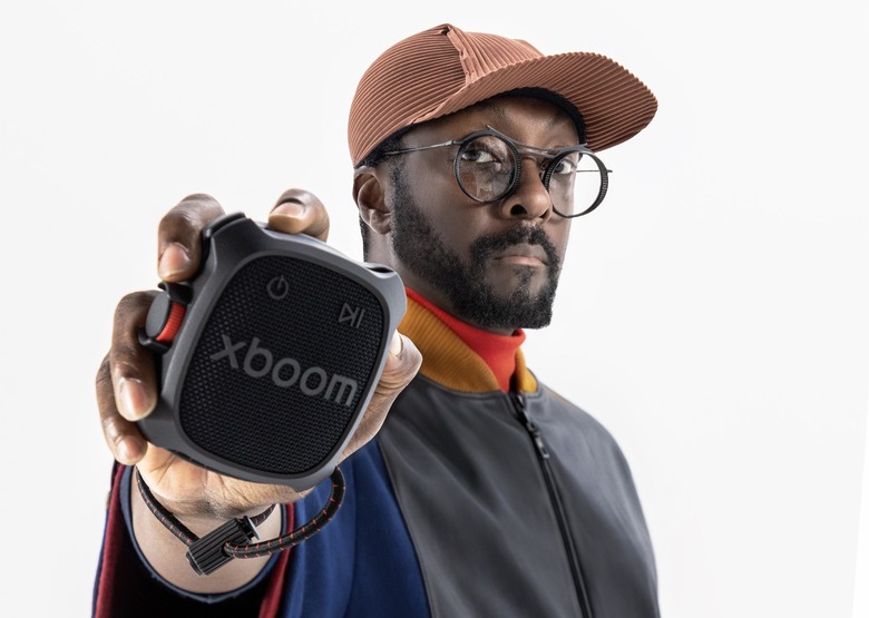 will.i.am holding a speaker. 
