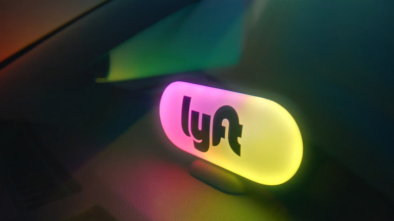 A colorful Lyft light on the inside of a dimly lit car.