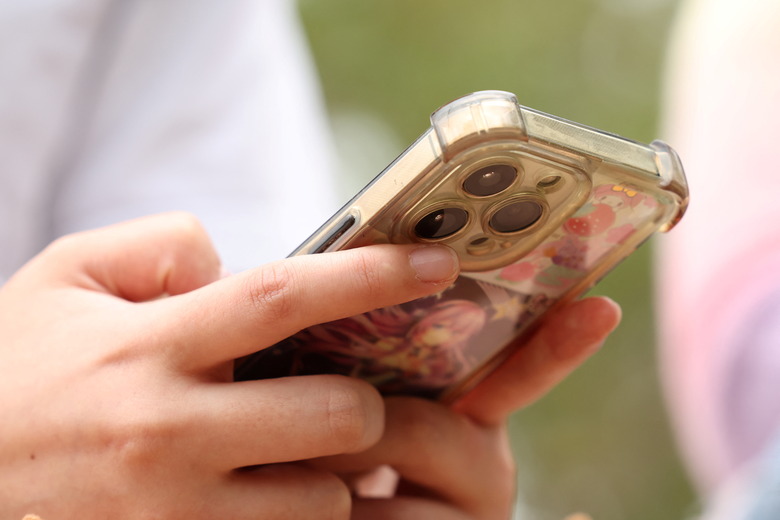 A girl uses her mobile phone after an interview discussing Australia's social media ban for users under 16, which is scheduled to take effect on December 10, in Sydney, Australia, November 22, 2025. REUTERS/Hollie Adams