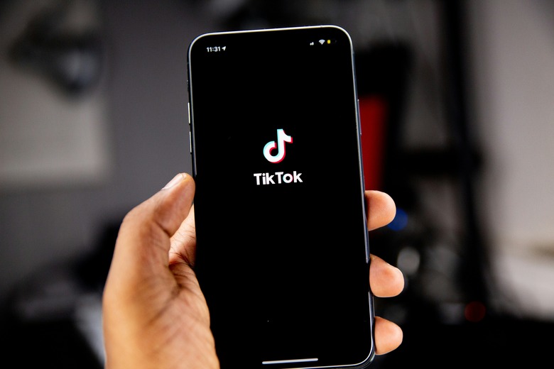 A hand holding a phone with TikTok on it.