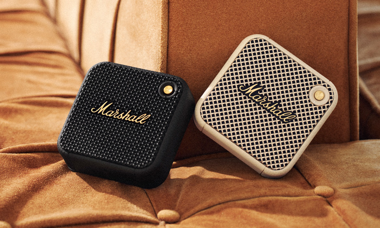 Two of the Marshall Willen micro Bluetooth speakers on a fabric banquet.