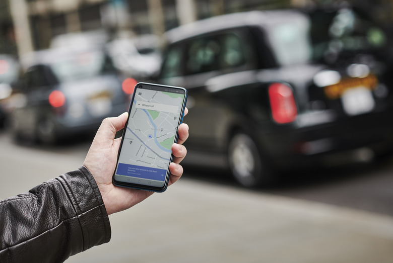 LONDON, UNITED KINGDOM - JUNE 4: Detail of a man holding up an Honor 20 Pro smartphone with the Uber transport app visible on screen, while taxis queue in the background, on June 4, 2019. (Photo by Olly Curtis/Future via Getty Images)