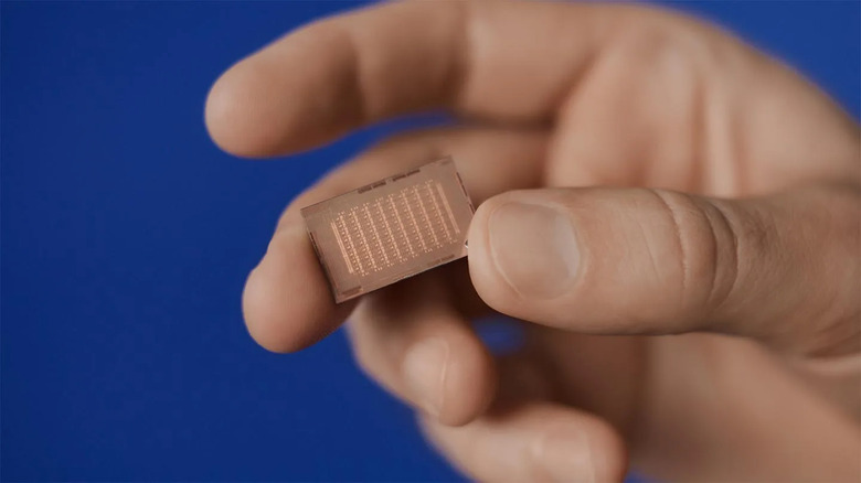 Closeup of a hand holding an in-house Meta AI chip.