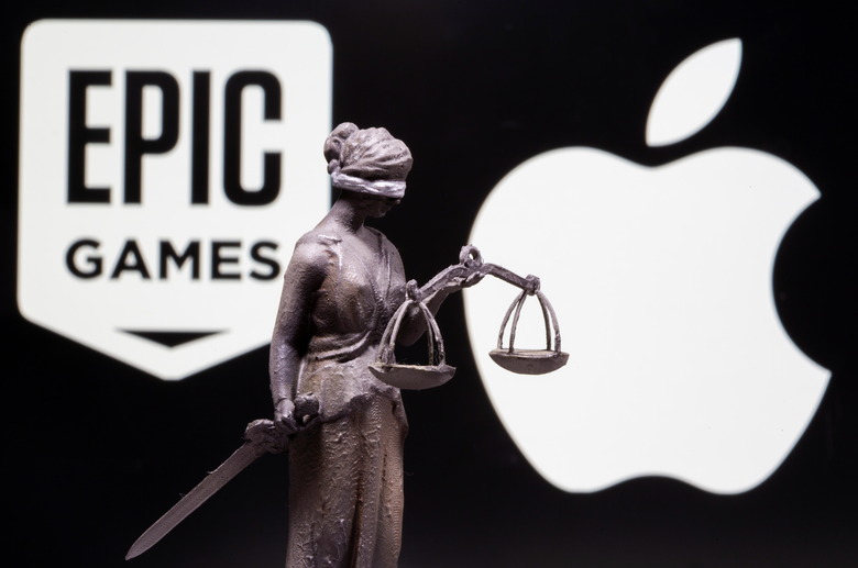3D printed Lady Justice figure is seen in front of displayed Apple and Epic Games logos in this illustration photo taken February 17, 2021. REUTERS/Dado Ruvic/Illustration