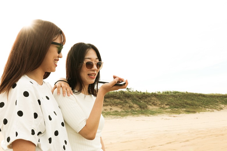 Two young asian woman is using voice recognition