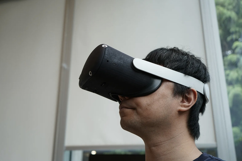 Researcher at Meta wearing a prototype Tiramisu VR headset. 