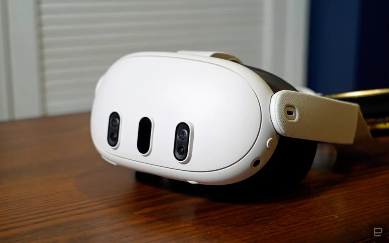 A white headset on top of a wooden table.