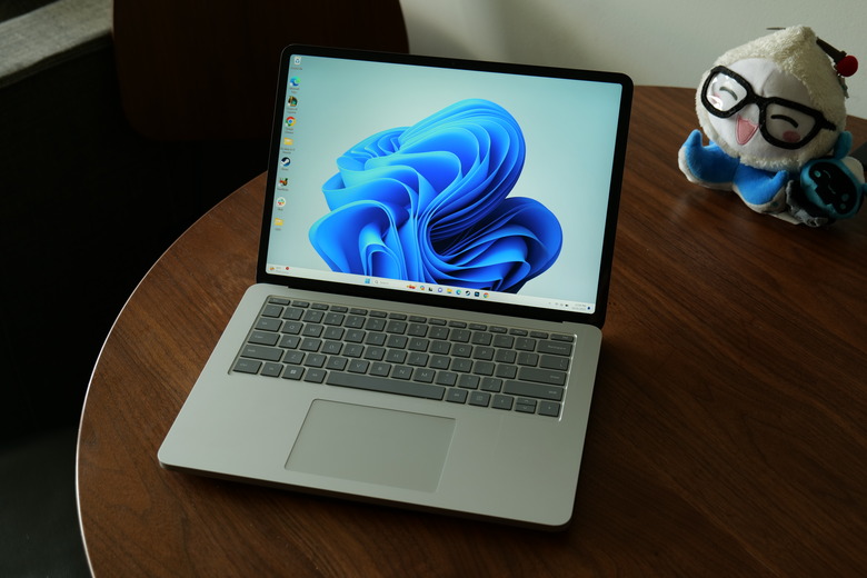 Product review photo of the Microsoft Surface Laptop 2, sitting on a desk next to a stuffed toy.