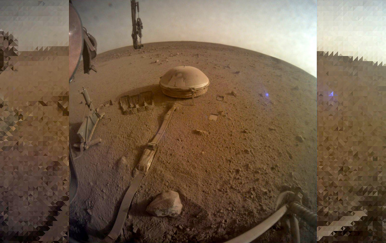 NASA InSight final image December 2022 showing the edges of its base and a small domed device a few feet away connected by a cable.