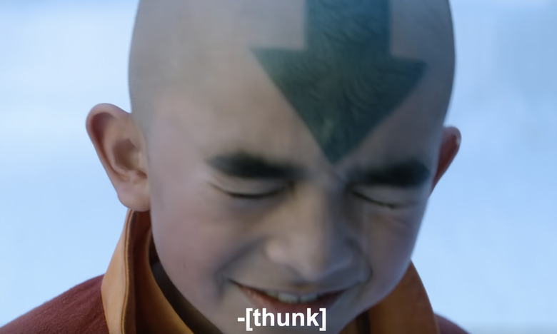 A still from the blooper reel of Avatar The Last Airbender showing the actor for Aang grimacing, with a caption that reads [thunk]