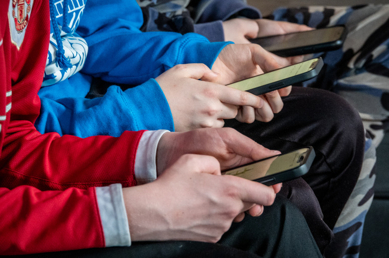 MORZINE, FRANCE - APRIL 08: Three teenage boys looks at their smartphone screens in village of St Jean d'Aulps on April 8, 2024 near Morzine, France. Following the lead of the EU Commission and several US administrations, TikTok is set to be banned from UK government phones amid security concerns around the Chinese-owned video app. Recently TikTok announced that every account belonging to a user below age 18 have a 60-minute daily screen time limit automatically set. (Photo by Matt Cardy/Getty Images)