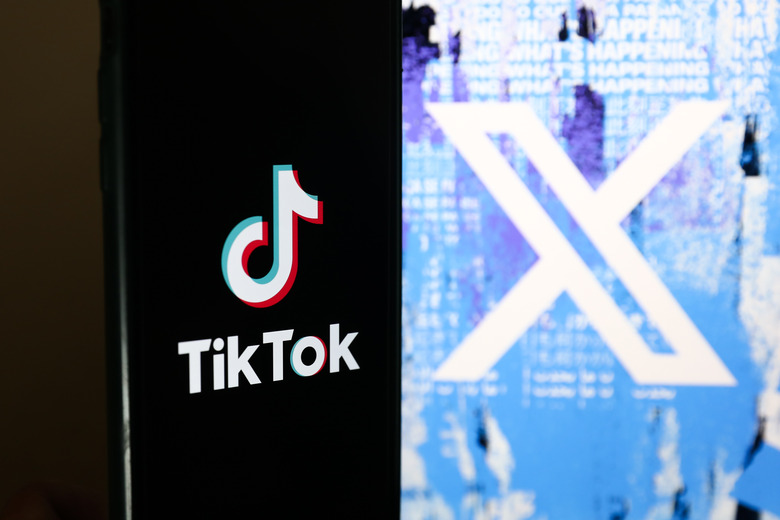 TikTok logo displayed on a phone screen and Twitter X logo on website displayed on a laptop screen are seen in this illustration photo taken in Warsaw, Poland on July 26, 2023. (Photo by Jakub Porzycki/NurPhoto via Getty Images)