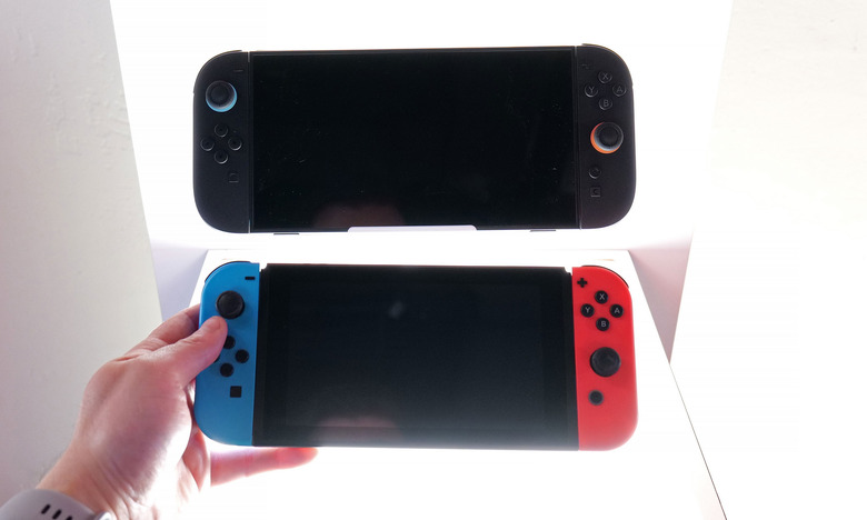 A Nintendo Switch is held next to a Nintendo Switch 2