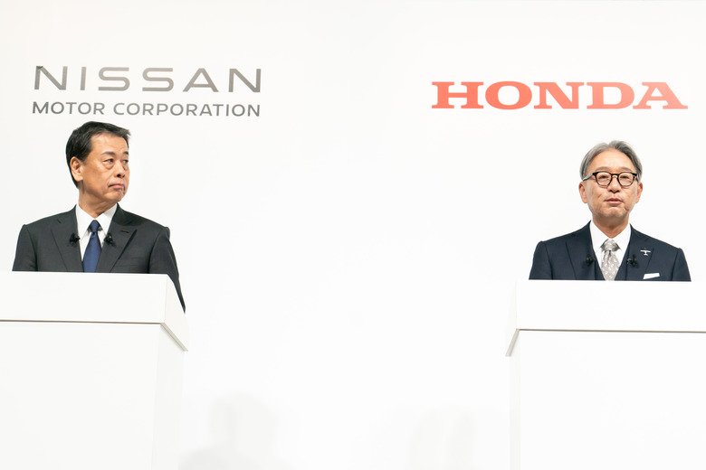 TOKYO, JAPAN - DECEMBER 23: Nissan Motor CEO Makoto Uchida (L) and Honda Motor CEO Toshihiro Mibe (R) attend a joint press conference on December 23, 2024, in Tokyo, Japan. Nissan and Honda announced they have begun merger negotiations, aiming to create the world's third-largest automotive group to compete with rival EV manufacturers such as China's BYD and the US-based Tesla.   (Photo by Tomohiro Ohsumi/Getty Images)