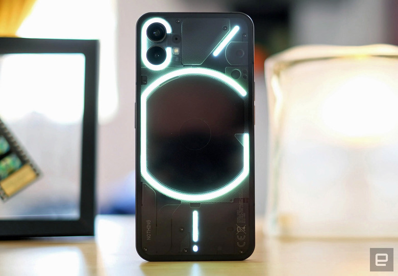 Nothing Phone (1) resting on a table, showing its Glyph light patterns.