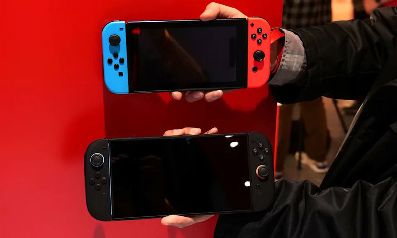 Two hands holding a pair of Switch 2 consoles.