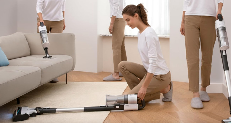 A woman using a vacuum.