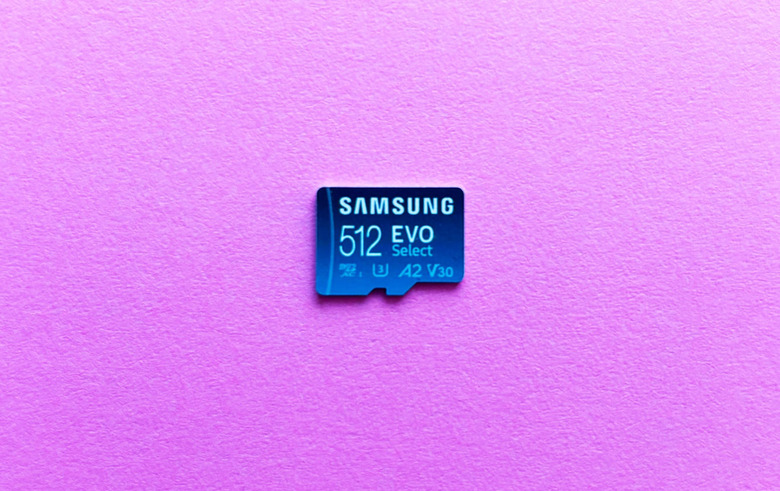 A light blue microSD card, the Samsung Evo Select, rest against a pink background.  