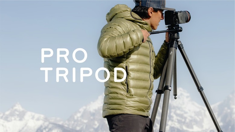 A person looking through a DSLR on a Peak Design Tripod. The text 