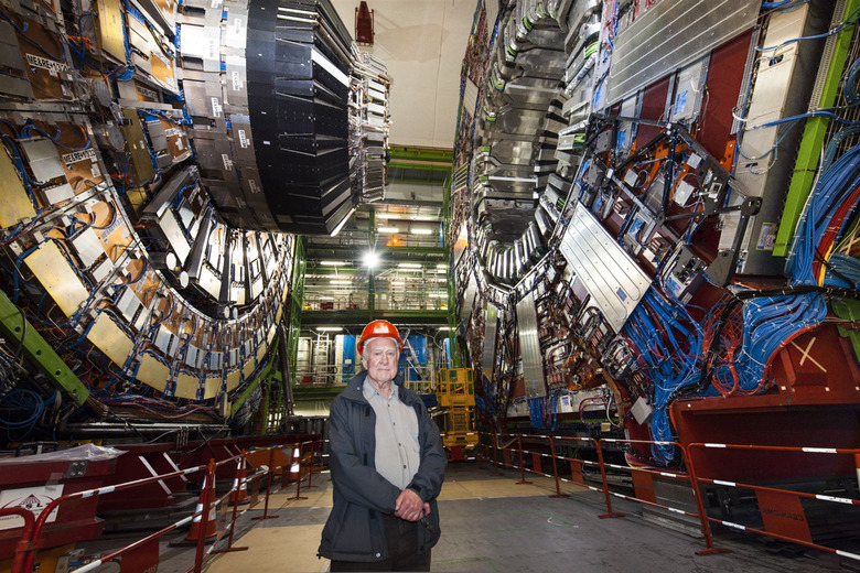 Peter Higgs standing in front of the Large Hadron collider.