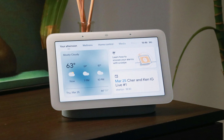 An image of a Google Nest Hub on a bedside table. 
