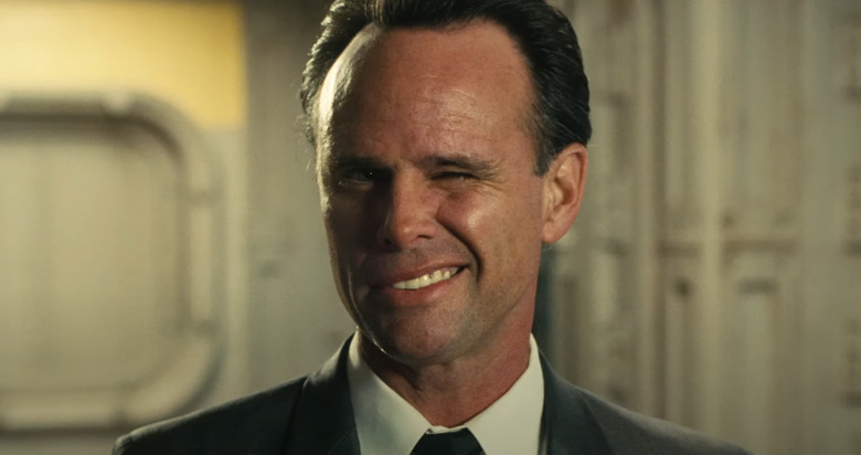 A middle-aged man winks at the camera.