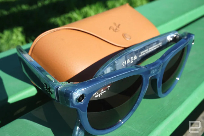 A paid of sunglasses propped against its case on a green bench.