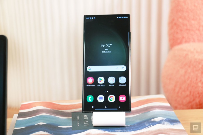 The Samsung Galaxy S23 Ultra on a stand on a book, with its screen facing front.