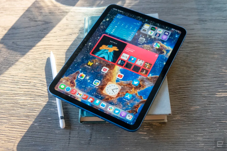 An iPad stacked on a book.