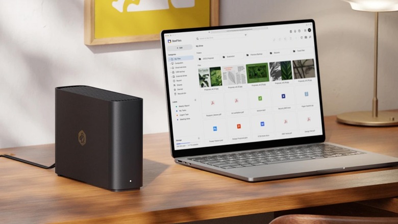 A Synology BeeStation NAS drive sits next to an Apple MacBook.