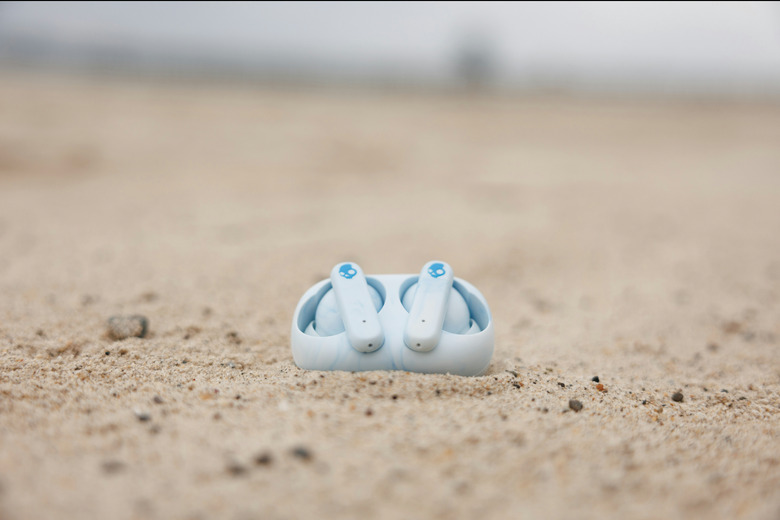 An image of earbuds in the sand. 