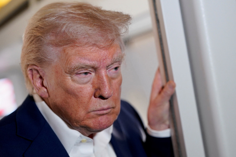 U.S. President Donald Trump looks on while on board Air Force One on the way to Palm Beach International Airport, West Palm Beach, Florida, U.S., April 11, 2025. REUTERS/Nathan Howard