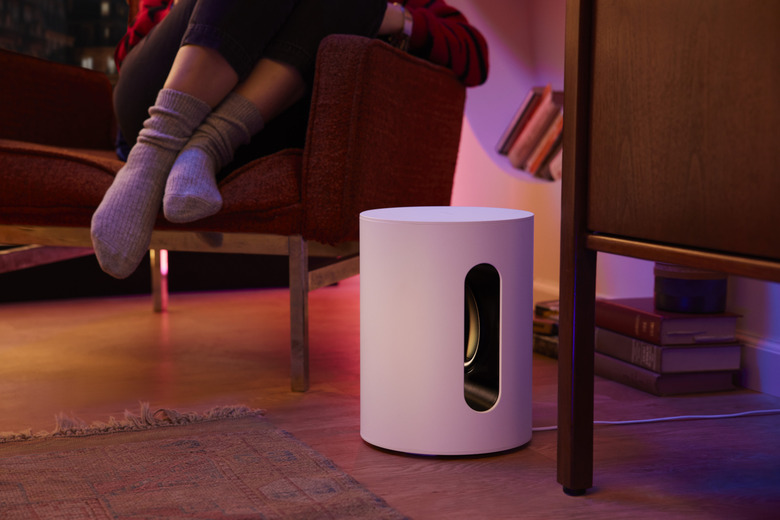 A white device with a person's feet in the background.