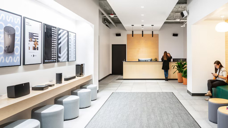 Photo of a modern office lobby with a couple of people along with a front-desk worker.