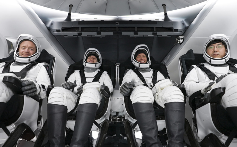 Four people in space suits.