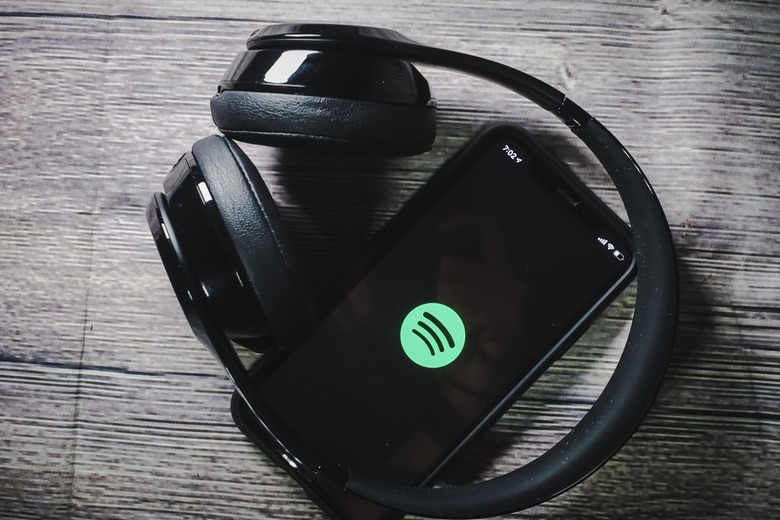 An iphone 11 screen showing spotify icon with beats earphone, perfect for listening musics on the go