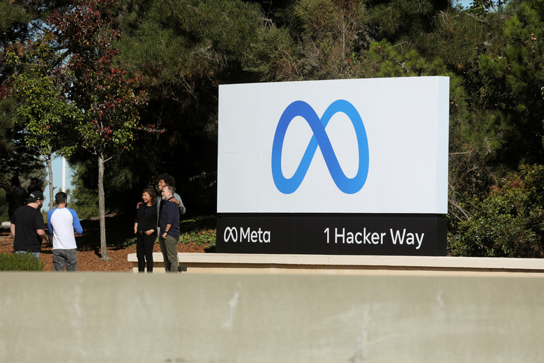 FILE PHOTO: People pose for a photo in front of a sign of Meta, the new name for the company formerly known as Facebook, at its headquarters in Menlo Park, California, U.S. October 28, 2021. REUTERS/Nathan Frandino/File Photo