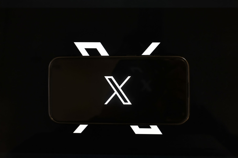 ANKARA, TURKIYE - DECEMBER 21: In this photo illustration, 'X' (formerly known as Twitter) logo is being displayed on a mobile phone screen in front of a computer screen with the logo of X in Ankara, Turkiye on December 21, 2023. (Photo by Yasin Baturhan Ergin/Anadolu via Getty Images)